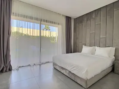 a bedroom with a large bed and a large window at Villa Léna détente en famille ! in Marrakech