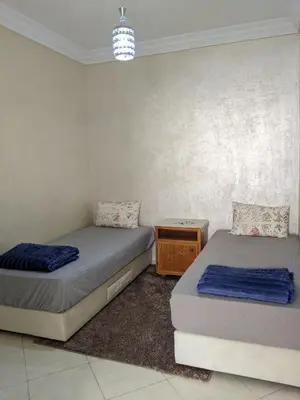 a room with two beds and a night stand at Marrakech apartment in Marrakech