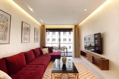 a living room with a red couch and a tv at Brand New and Stylish appart hotel Best location in Marrakech