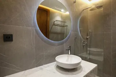 a bathroom with a white sink and a mirror at Brand New and Stylish appart hotel Best location in Marrakech