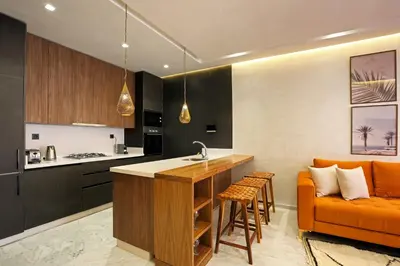 a kitchen and living room with an orange couch at Brand New and Stylish appart hotel Best location in Marrakech
