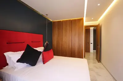a bedroom with a white bed with a red headboard at Brand New and Stylish appart hotel Best location in Marrakech
