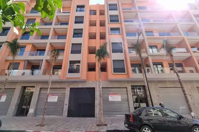a car parked in front of a building with palm trees at Brand New and Stylish appart hotel Best location in Marrakech