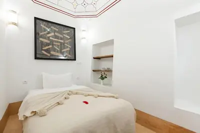 a white bedroom with a bed in a room at Riad Petit Pouce 40m2 in der Medina mit Terrasse in Marrakech