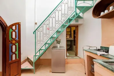 a stairway with a green railing in a kitchen at Riad Petit Pouce 40m2 in der Medina mit Terrasse in Marrakech