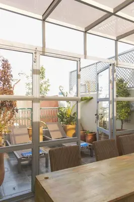 a patio with a table and chairs and windows at Riad Dar Habiba 120m2 in der Medina mit Terrasse in Marrakech
