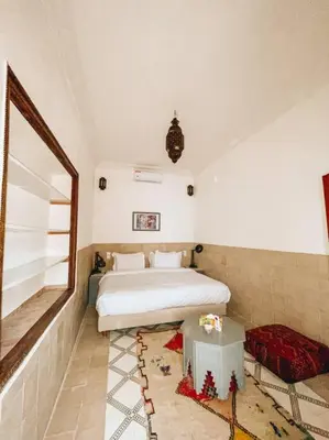 a bedroom with a bed and a table in it at Riad Dar Habiba 120m2 in der Medina mit Terrasse in Marrakech