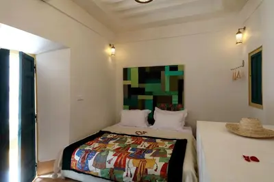 a bedroom with a bed with a colorful quilt on it at Riad Haloma 90m2 in der Medina mit Terrasse in Marrakech