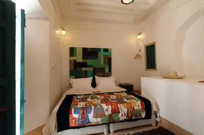 a bedroom with a bed with a colorful quilt on it at Riad Haloma 90m2 in der Medina mit Terrasse in Marrakech