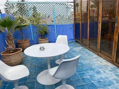 a white table and chairs in a room with plants at Riad Haloma 90m2 in der Medina mit Terrasse in Marrakech