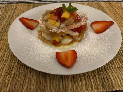 a white plate with a dessert with strawberries on it at Riad Saadaoui in Marrakech