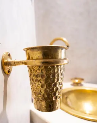 a gold bucket sitting on a counter next to a sink at Riad Saadaoui in Marrakech