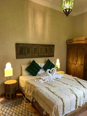 a bedroom with a bed with two swans on it at Riad Saadaoui in Marrakech