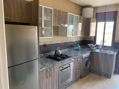 a kitchen with a refrigerator and a washer and dryer at Luxury Appartement with Pool in Marrakech