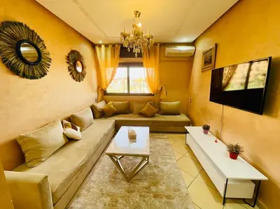 a living room with a couch and a tv at Centre ville Majorelle avec Parking gratuit in Marrakech