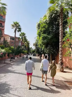 three people walking down a street with palm trees at Centre ville Majorelle avec Parking gratuit in Marrakech
