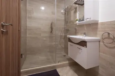 a bathroom with a shower with a sink and a mirror at Charming two bedrooms Flat with Pool and Parking in Marrakech
