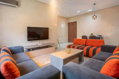 a living room with couches and a flat screen tv at Charming two bedrooms Flat with Pool and Parking in Marrakech