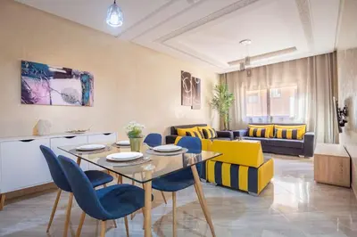 a living room with a table and blue chairs at Spacious 2 BR FLAT with Wi-Fi, Pool and Parking in Marrakech