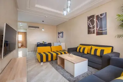 a living room with yellow and blue couches and a table at Spacious 2 BR FLAT with Wi-Fi, Pool and Parking in Marrakech