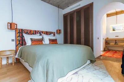 a bedroom with a large bed with a green blanket at Riad Doum Collection 2 in Marrakech