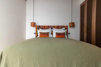 a bedroom with a large green bed with two pillows at Riad Doum Collection 2 in Marrakech