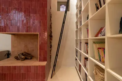 a room with a fireplace with bookshelves at Riad & Spa, Doum Collection in Marrakech