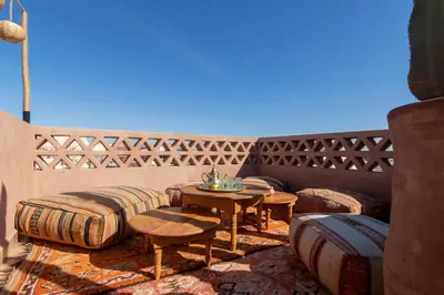 a patio with tables and chairs and a fence at Riad & Spa, Doum Collection in Marrakech