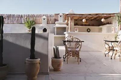 a patio with chairs and a table and cactus at Riad Soulmate in Marrakech