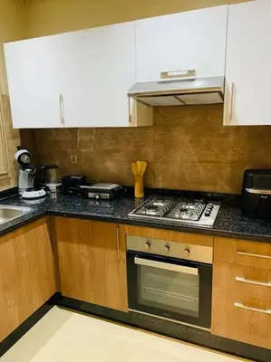 a kitchen with white cabinets and a stove top oven at Expérience luxueuse Golf Prestigia Saphir BY KECH in Marrakech