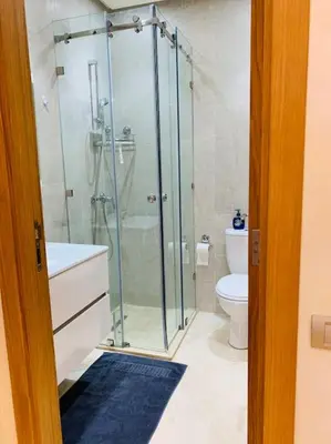 a bathroom with a glass shower and a toilet at Expérience luxueuse Golf Prestigia Saphir BY KECH in Marrakech