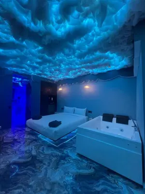 a bedroom with a bed and a bathtub and clouds painted on the ceiling at Tête dans les nuages ! Jacuzzi in Marrakech