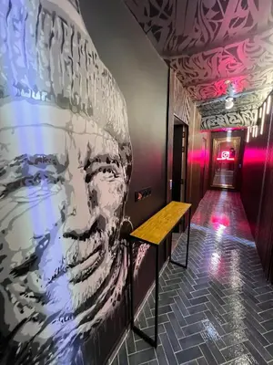 a hallway with a mural of a face on the wall at Tête dans les nuages ! Jacuzzi in Marrakech