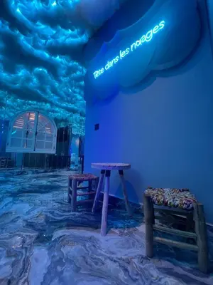 a blue room with two benches and a sign on the wall at Tête dans les nuages ! Jacuzzi in Marrakech