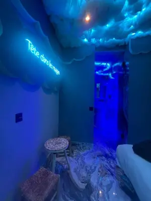 a blue room with a stool and a sign on the ceiling at Tête dans les nuages ! Jacuzzi in Marrakech