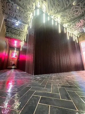 a room with a stone floor and a wall with pink lights at Tête dans les nuages ! Jacuzzi in Marrakech