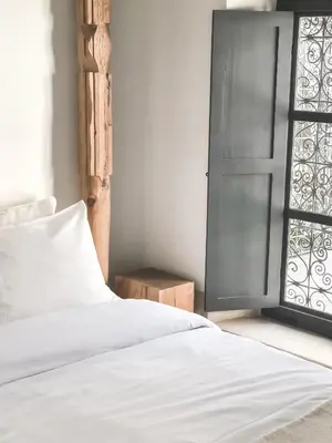 a bedroom with a white bed and a window at Riad Dar-K in Marrakech