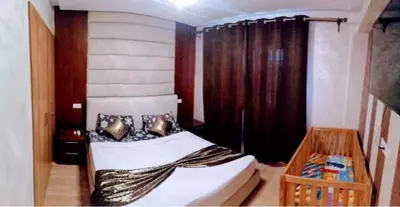 a bedroom with a bed in a room with curtains at Un élégant appartement à louer à Marrakech avec deux piscines et une situation en centre ville in Marrakech