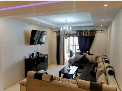 a living room with a couch and a tv at Un élégant appartement à louer à Marrakech avec deux piscines et une situation en centre ville in Marrakech