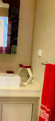 a bathroom with a sink and a red towel at Appartement calme et élégant au coeur de Marrakech in Marrakech
