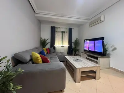 a living room with a couch and a flat screen tv at Appartement Chic au Coeur Gueliz Marrakech in Marrakech