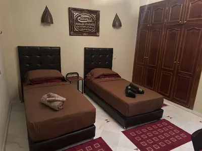 two beds sitting next to each other in a room at Magnifique appartement 2 chambres et piscine de standing in Marrakech