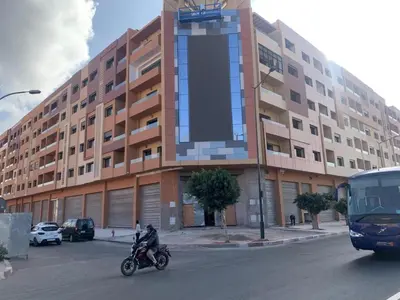 a man riding a motorcycle in front of a building at Appartement Nour 5 Marrakech in Marrakech