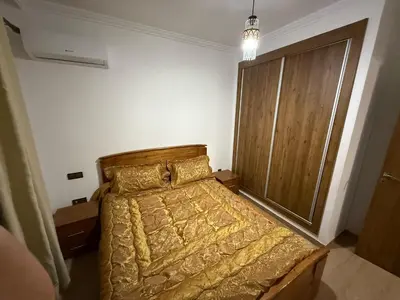 a bedroom with a bed and a wooden door at Appartement Nour 5 Marrakech in Marrakech
