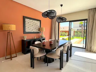 a dining room with orange walls and a table and chairs at Palais Siham in Marrakech