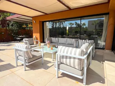 a group of chairs and a glass table on a patio at Palais Siham in Marrakech