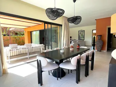 a dining room with a black table and chairs at Palais Siham in Marrakech