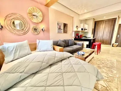 a bedroom with a large bed and a couch at Appartement elegant et securise au centre de Marrakech in Marrakech