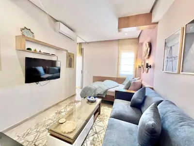 a living room with a blue couch and a tv at Appartement elegant et securise au centre de Marrakech in Marrakech
