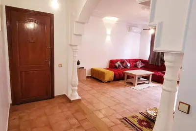 a living room with a red couch and a table at Appartement bien équipé à louer in Marrakech